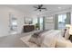 This bedroom offers bright natural light with a ceiling fan, carpeted floors and a primary bath at 6514 W Apex Ave, Queen Creek, AZ 85144
