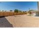 Expansive gravel backyard featuring a wooden fence, small tree, and covered patio, perfect for outdoor enjoyment at 6610 N 15Th Ave, Phoenix, AZ 85015