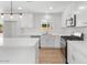 Bright kitchen boasts white cabinets, quartz countertops, stainless steel appliances, and an island with pendant lighting at 6610 N 15Th Ave, Phoenix, AZ 85015