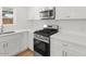 Modern kitchen features white cabinetry, quartz counters, and stainless steel appliances, including microwave and range at 6610 N 15Th Ave, Phoenix, AZ 85015