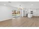Open-concept living area with light wood floors, sliding glass doors, and a view into the bright, modern kitchen at 6610 N 15Th Ave, Phoenix, AZ 85015