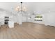 Open concept living room and kitchen with light wood floors and white cabinets, creating a modern and cohesive living space at 6610 N 15Th Ave, Phoenix, AZ 85015
