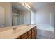 Bathroom with double sink vanity and glass enclosed shower/tub combo at 8010 W Adam Ave, Peoria, AZ 85382