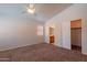 Neutral bedroom showcasing carpeted flooring, a window and an adjoining bathroom with wood vanity at 8010 W Adam Ave, Peoria, AZ 85382