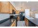 Kitchen with island, black appliances, and oak cabinets at 8010 W Adam Ave, Peoria, AZ 85382