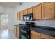 Bright kitchen features wood cabinetry, black appliances, and durable countertops at 8010 W Adam Ave, Peoria, AZ 85382