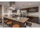 Modern kitchen with granite countertops, stainless steel appliances, and a large island with seating at 8220 E Crestwood Way, Scottsdale, AZ 85250