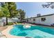 Inviting backyard pool with a large inflatable swan, lounge chairs and a well-manicured lawn at 8220 E Crestwood Way, Scottsdale, AZ 85250