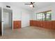 Comfortable bedroom with wainscoting, a ceiling fan, and closet doors at 944 E Melody Dr, Gilbert, AZ 85234