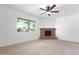 Bright living room with a brick fireplace, carpet flooring and a big window at 944 E Melody Dr, Gilbert, AZ 85234
