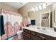 Cozy bathroom featuring a vanity with a granite countertop, a decorative shower curtain, and a warm ambiance at 1115 E Locust Dr, Chandler, AZ 85286
