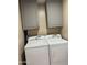 Functional laundry room with overhead cabinets and modern side-by-side washer and dryer at 11817 W Sierra St, El Mirage, AZ 85335