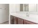 Bathroom vanity with white countertop, brown cabinets, silver faucet, and shower behind a clear door at 1239 E Elaine St, Casa Grande, AZ 85122