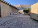 View of the backyard with gravel areas and shade structure, ready for outdoor living and relaxation at 13031 W Surrey Ave, El Mirage, AZ 85335