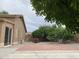 Spacious backyard with block wall, patio, and mature trees at 13031 W Surrey Ave, El Mirage, AZ 85335