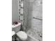 Bathroom with tiled shower, grab bars, patterned shower curtain and hexagon tiled floor at 13031 W Surrey Ave, El Mirage, AZ 85335