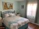 Cozy bedroom featuring comfortable bed and side tables with floral accents at 13031 W Surrey Ave, El Mirage, AZ 85335