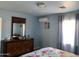 Bright bedroom showcasing a large dresser, window with curtains, and a light-filled atmosphere at 13031 W Surrey Ave, El Mirage, AZ 85335