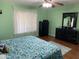 Serene bedroom featuring a ceiling fan, bright window, and dark-colored dresser with mirror at 13031 W Surrey Ave, El Mirage, AZ 85335
