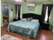 Comfortable bedroom showcasing green walls, dark accents, and access to an ensuite bathroom at 13031 W Surrey Ave, El Mirage, AZ 85335