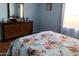 Cozy bedroom featuring a dresser with a mirror and floral bedding at 13031 W Surrey Ave, El Mirage, AZ 85335