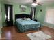 Inviting bedroom with mint green walls, dark furniture, and a blue floral-patterned bedspread at 13031 W Surrey Ave, El Mirage, AZ 85335