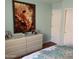 Bedroom featuring a dresser with decor and artwork on the light blue walls at 13031 W Surrey Ave, El Mirage, AZ 85335
