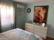 Bedroom featuring a comfortable bed, dresser, and bright, sunny window at 13031 W Surrey Ave, El Mirage, AZ 85335
