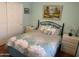 Bedroom with comfortable bed, side tables, and art on the light blue walls at 13031 W Surrey Ave, El Mirage, AZ 85335