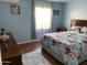 Comfortable bedroom with a spacious dresser, bright window, and patterned bedspread at 13031 W Surrey Ave, El Mirage, AZ 85335