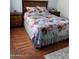 Relaxing bedroom with matching nightstands, a floral bedspread, and warm wood flooring at 13031 W Surrey Ave, El Mirage, AZ 85335