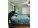 This bedroom boasts hardwood floors, a decorative ceiling fan, and a lovely floral comforter at 13031 W Surrey Ave, El Mirage, AZ 85335
