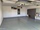 Spacious garage with epoxy floor, overhead lighting, and built-in storage cabinets at 13031 W Surrey Ave, El Mirage, AZ 85335