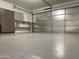 Clean, epoxy-floored garage featuring overhead door and built-in storage cabinets at 13031 W Surrey Ave, El Mirage, AZ 85335