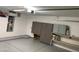 Well-lit garage with ample storage space, epoxy flooring, and access door at 13031 W Surrey Ave, El Mirage, AZ 85335