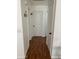 Bright hallway featuring wood-look floors and white walls with neutral doors at 13031 W Surrey Ave, El Mirage, AZ 85335