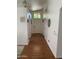 Bright hallway with wood flooring leading to the front door for welcoming entry at 13031 W Surrey Ave, El Mirage, AZ 85335