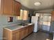 Neutral kitchen featuring wood cabinets, double sink, and access to backyard patio at 13031 W Surrey Ave, El Mirage, AZ 85335
