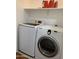 Practical laundry area featuring a front-load washer and dryer with overhead storage at 13031 W Surrey Ave, El Mirage, AZ 85335