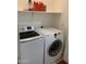Well-equipped laundry room with a modern washer and dryer set and storage shelf at 13031 W Surrey Ave, El Mirage, AZ 85335