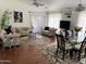 Bright living room featuring elegant furniture, wood floors, ceiling fan, and plentiful natural light at 13031 W Surrey Ave, El Mirage, AZ 85335