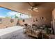 Charming covered back patio with comfortable seating, ceiling fan, and a landscaped block wall for privacy at 13821 N Thunderbird Blvd, Sun City, AZ 85351
