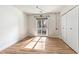 Bedroom featuring wood floors, a sliding glass door, and a closet, offering a simple, sunlit space at 13821 N Thunderbird Blvd, Sun City, AZ 85351
