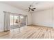 Spacious bedroom with wood floors, ceiling fan, sliding glass doors to the patio, and lots of natural light at 13821 N Thunderbird Blvd, Sun City, AZ 85351