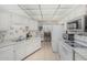 Efficient white kitchen featuring tile flooring, ample cabinet space, and white appliances at 13821 N Thunderbird Blvd, Sun City, AZ 85351