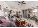 Spacious living room featuring a ceiling fan, light wood floors, and sliding glass door to the outside patio at 13821 N Thunderbird Blvd, Sun City, AZ 85351
