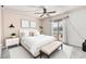 Main bedroom with a large window, ceiling fan, white bed, bench, and soft colors at 13821 N Thunderbird Blvd, Sun City, AZ 85351