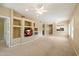 Spacious living room with neutral carpet, ceiling fans, built-ins, and natural light at 13850 N Mirage Heights Ct # 201, Fountain Hills, AZ 85268