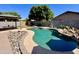 Spacious backyard featuring a pool, covered patio, fire pit, artificial turf, and ample space for outdoor enjoyment at 14282 W Indianola Ave, Goodyear, AZ 85395