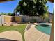 Inviting backyard featuring a pool, fire pit, artificial turf, and ample space for outdoor enjoyment and relaxation at 14282 W Indianola Ave, Goodyear, AZ 85395